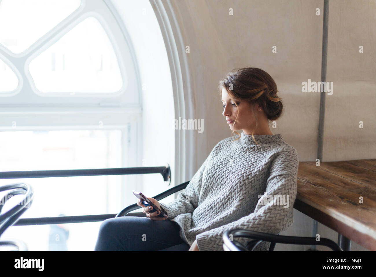 Hermosa mujer joven con smartphone en cafe Foto de stock