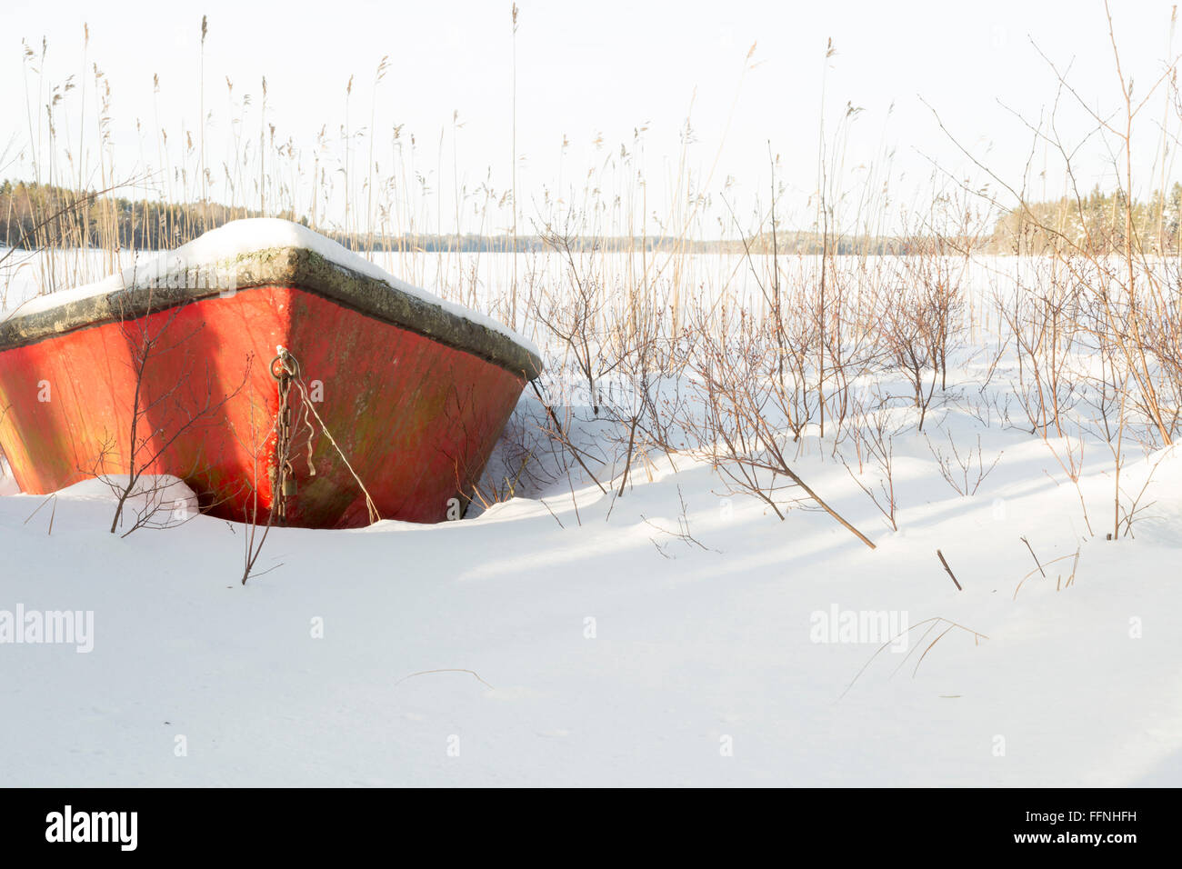 Botes cubiertos de nieve por el lago Foto de stock