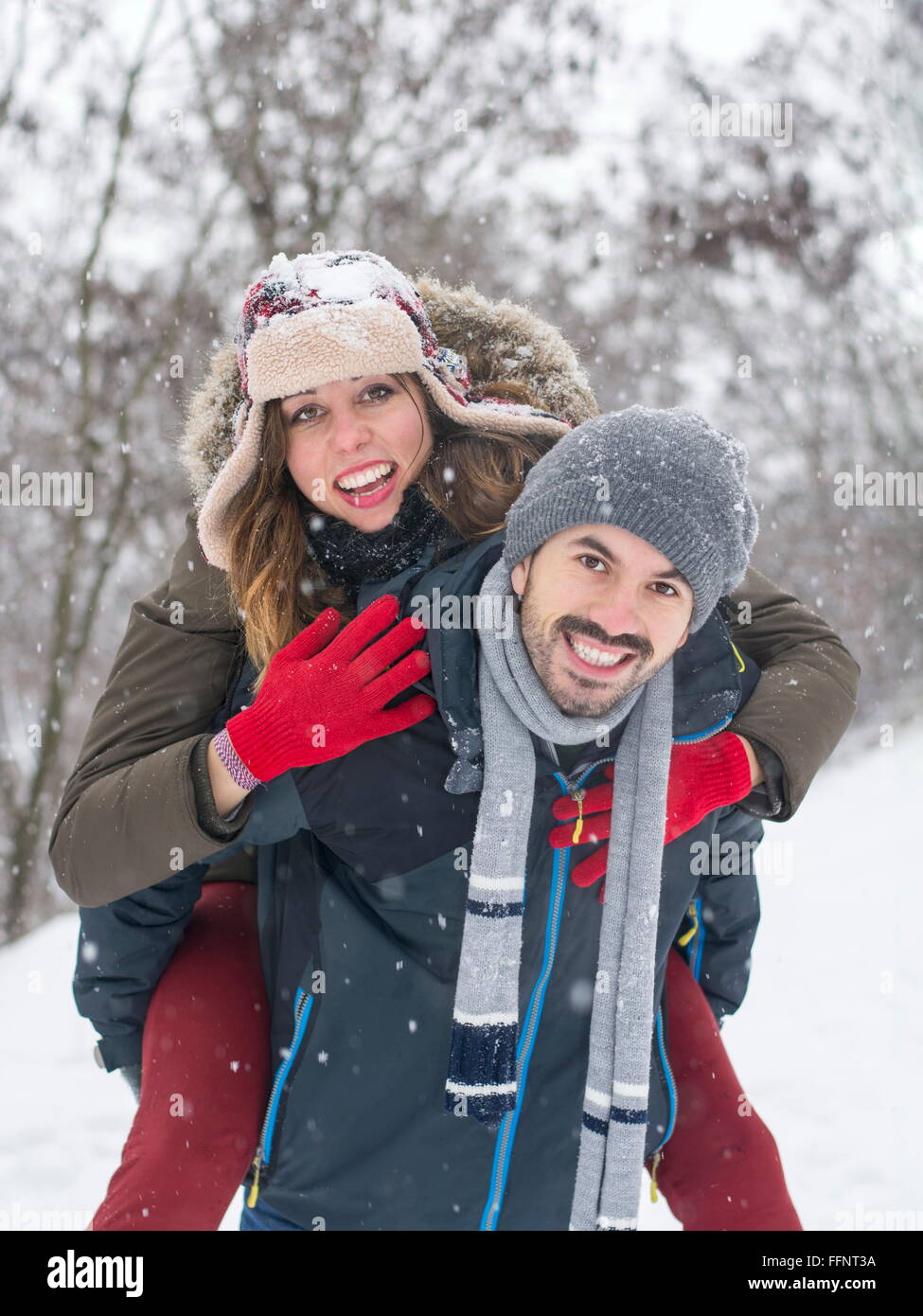 Pareja en amor a divertirse al aire libre en un día nevado de invierno Foto de stock