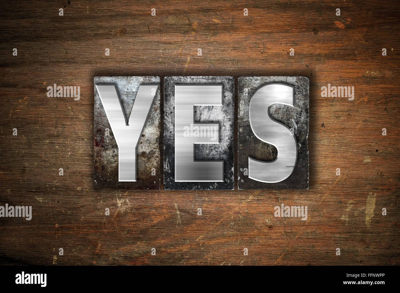 La palabra "Sí" escrito en vintage tipografía metálica sobre un fondo de madera envejecida. Foto de stock