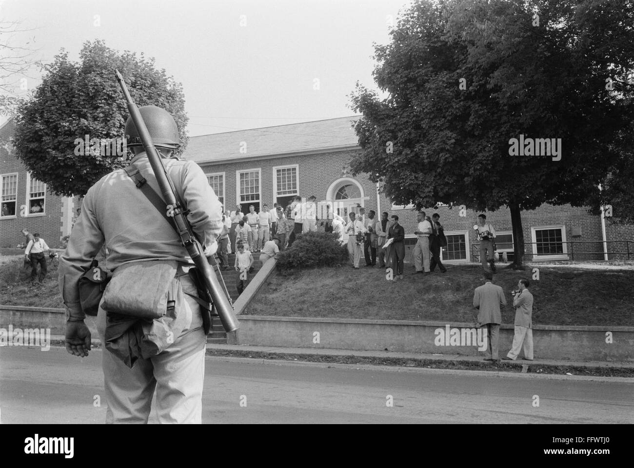 La integración escolar, 1956. /NAn Guardia Nacional armado observa como un grupo de los primeros estudiantes negros son admitidos a Clinton High School en Clinton, Tennessee, el 1 de septiembre de 1956. Foto de stock