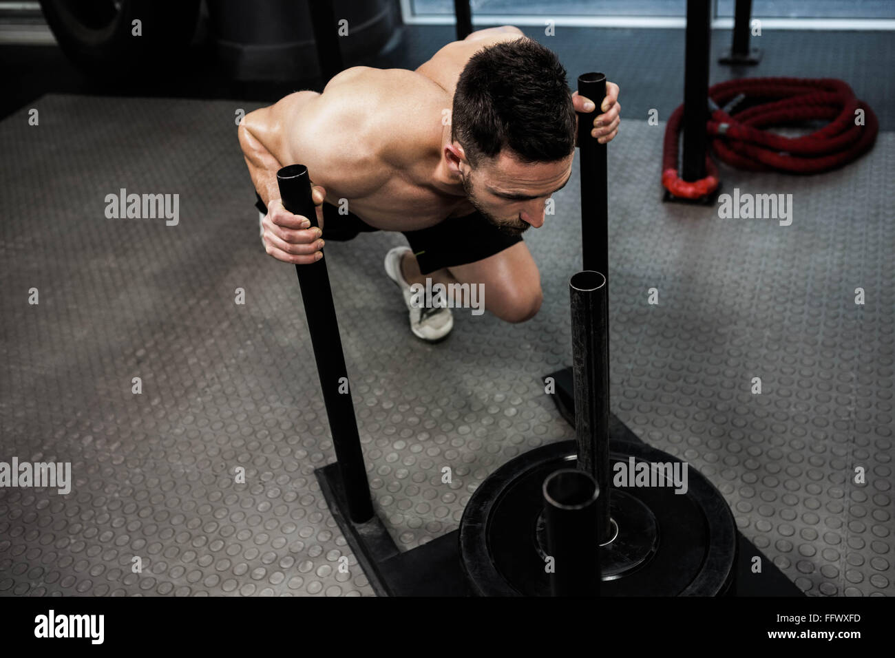 Empujar el trineo de Crossfit hombre empujando pesos ejercicio de  entrenamiento Fotografía de stock - Alamy