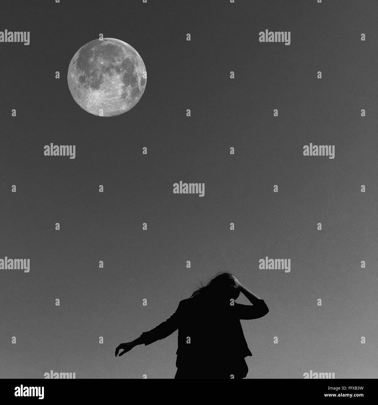 Ángulo de visión baja de la mujer contra la Luna Foto de stock