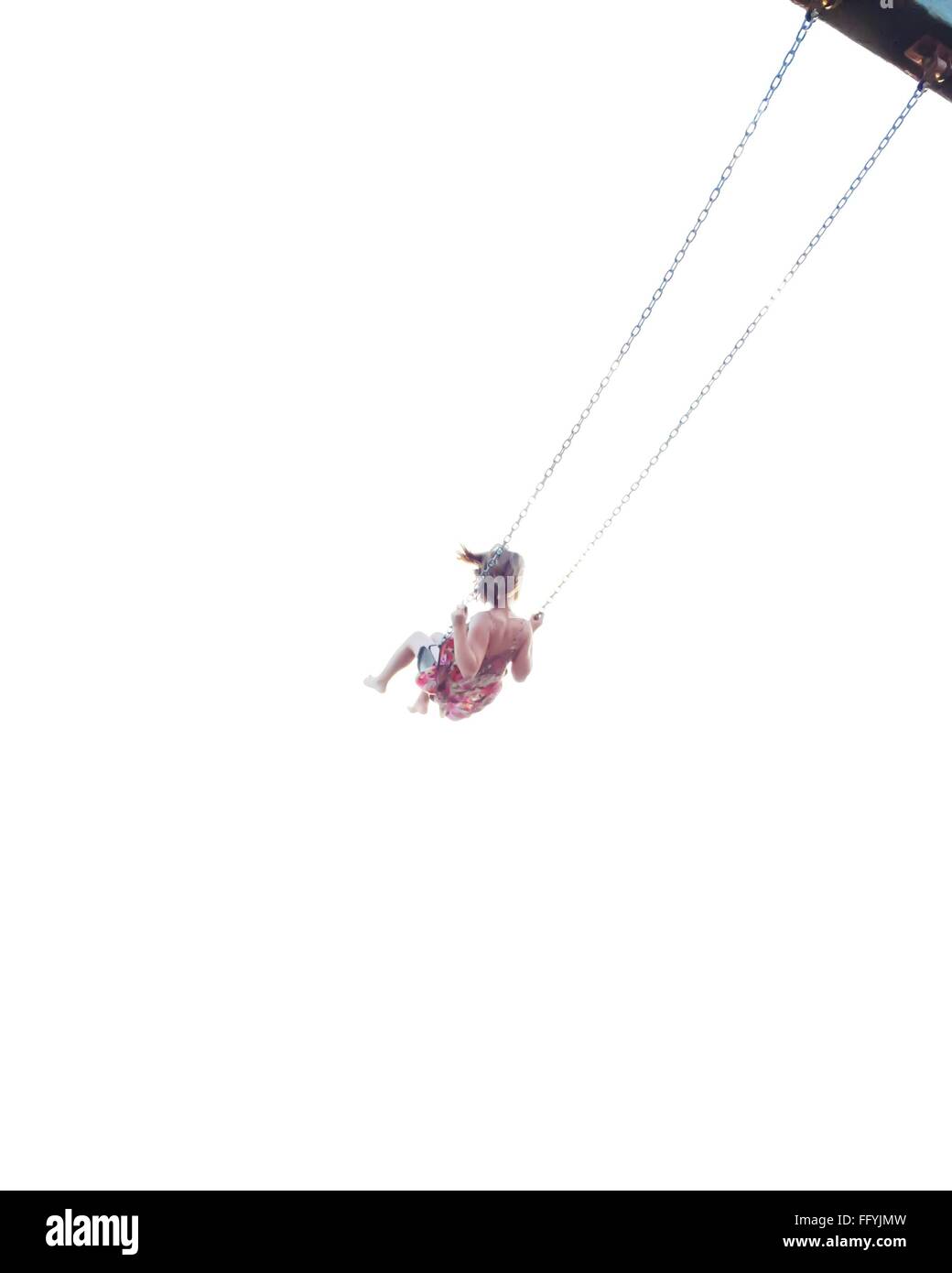 Ángulo de visión baja de la mujer disfruta de Swing contra el cielo claro Foto de stock
