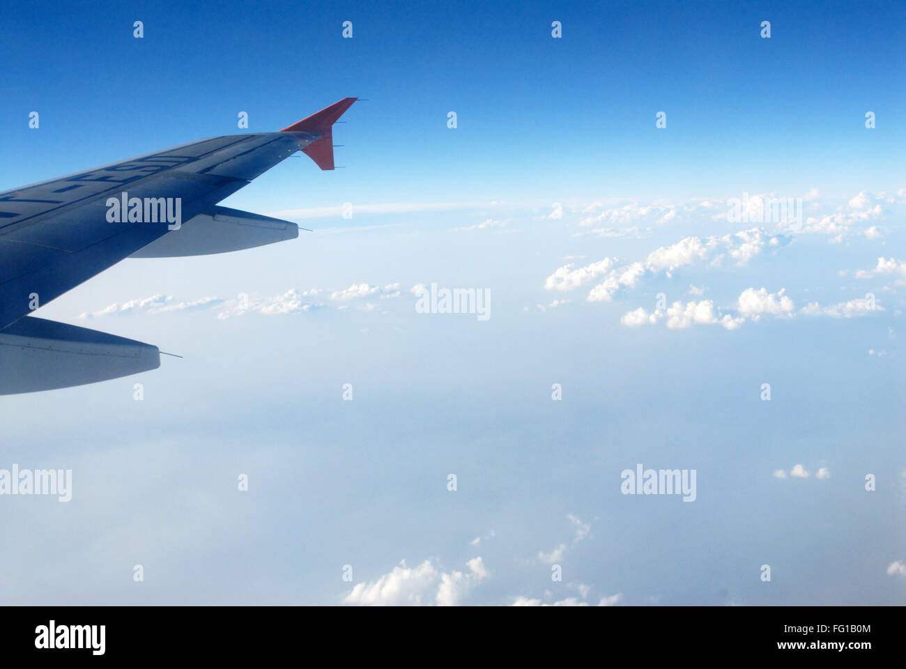 Transporte aéreo , vista de ala y nubes en el cielo azul desde la ventana del avión Foto de stock