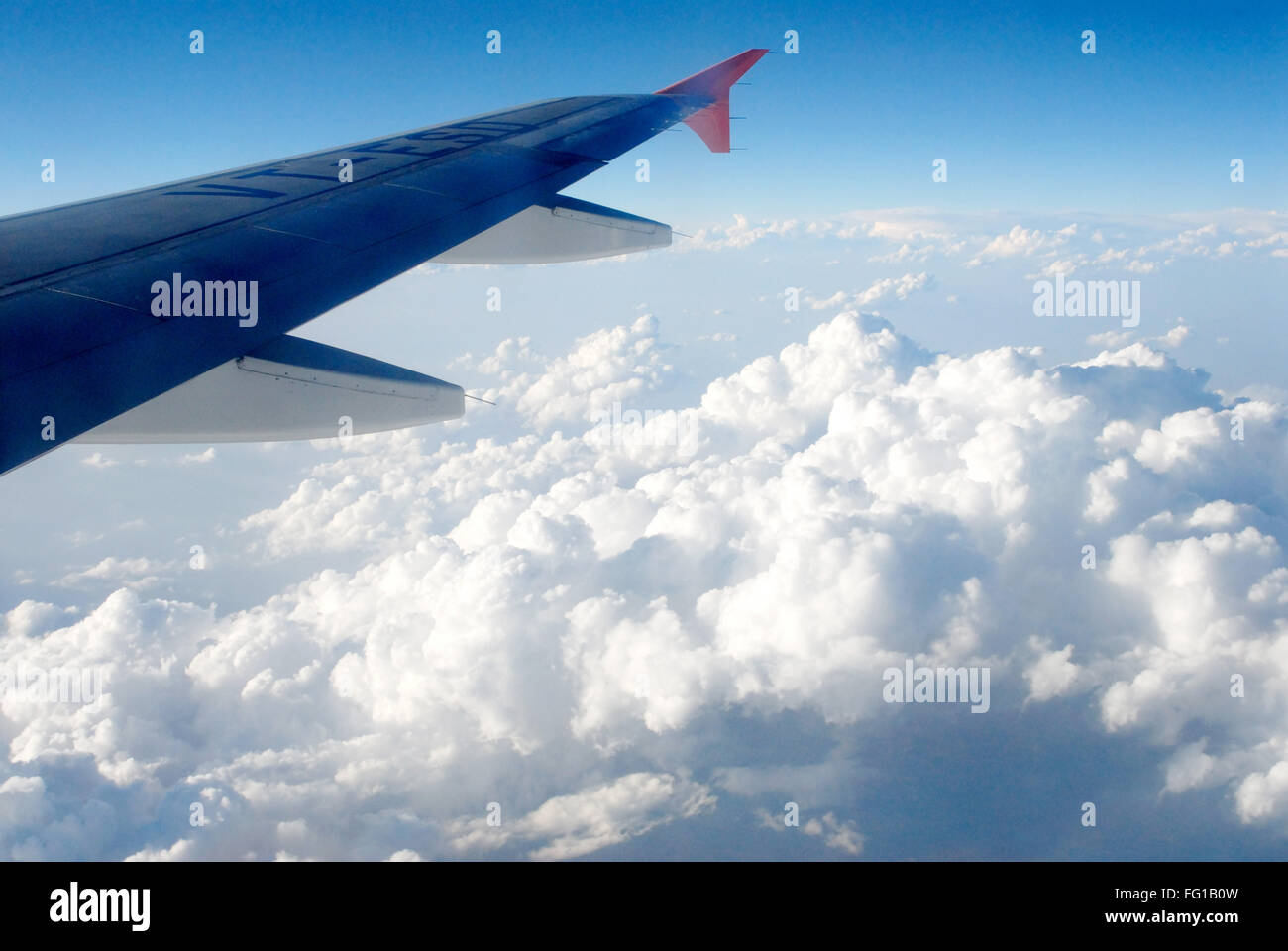 Transporte aéreo , vista de ala y nubes en el cielo azul desde la ventana del avión Foto de stock