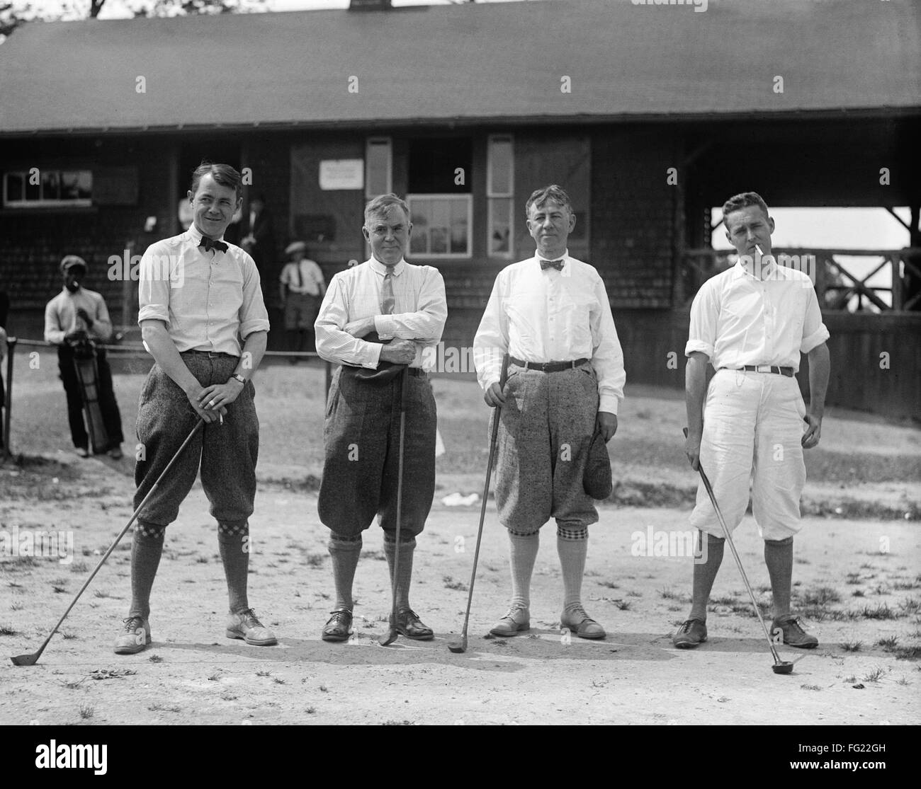 GOLF: hombres, 1924. /NMen vistiendo ropa de golf y celebración de los clubes de golf. Fotografía, 1924. Foto de stock