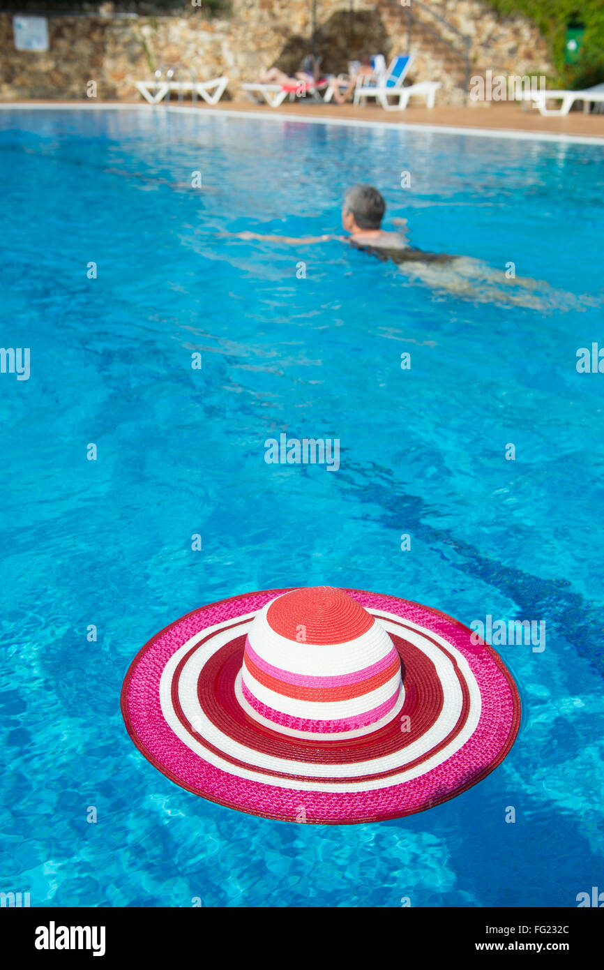 Piscina de lujo con rosa sombrero para el sol femenino Foto de stock