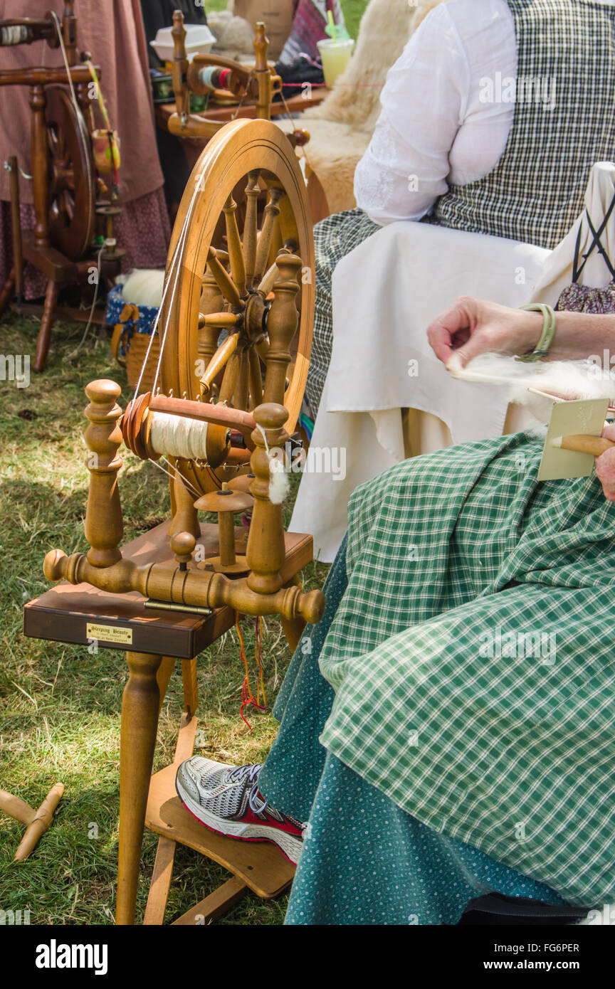 Mujer hilando lana en hilo con una rueda giratoria en la Feria del Condado de Clackamas, Canby, Oregón Foto de stock