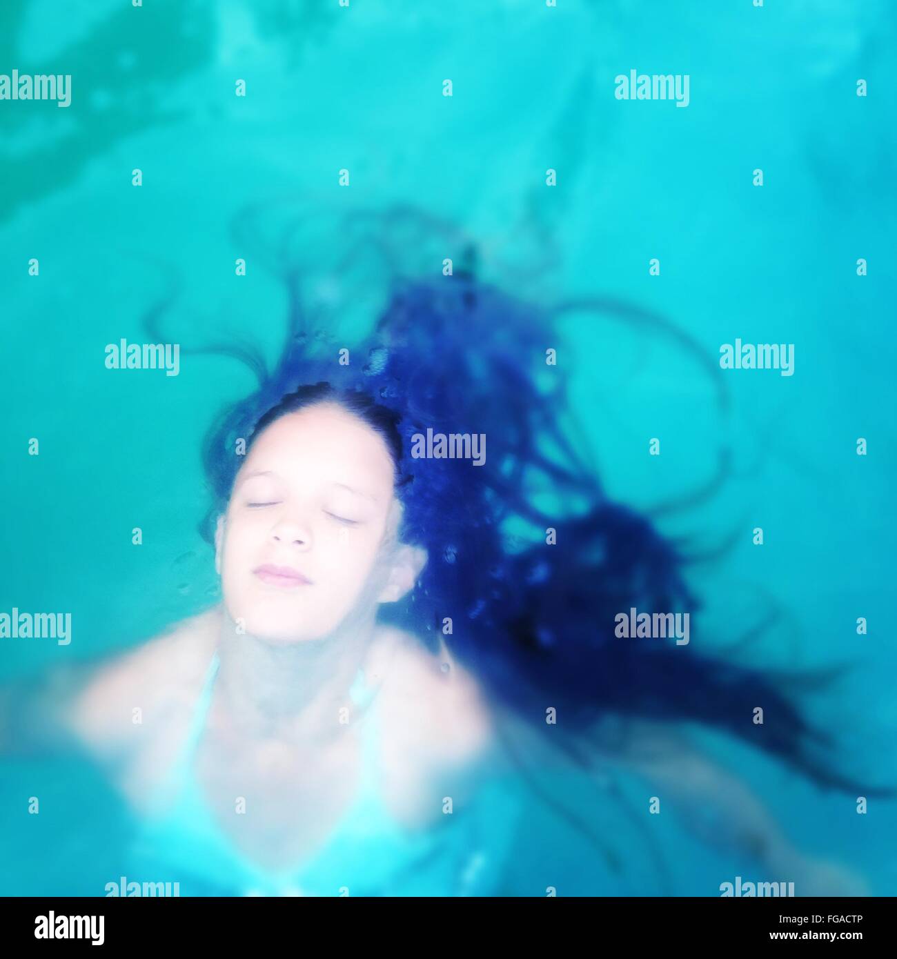 Un alto ángulo de visualización de la mujer joven con los ojos cerrados en la piscina Foto de stock