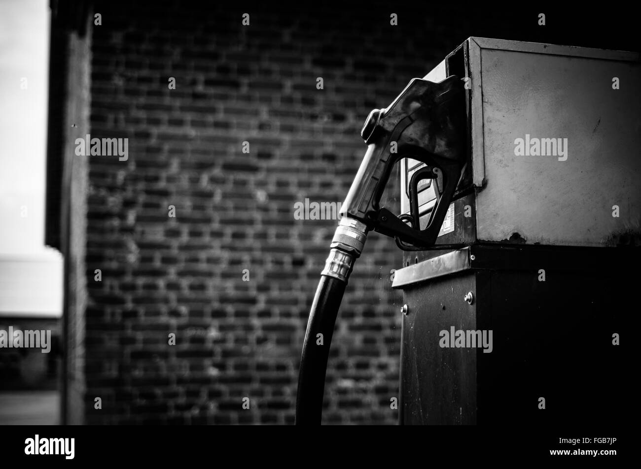 Bomba de gasolina contra la pared de ladrillo Foto de stock