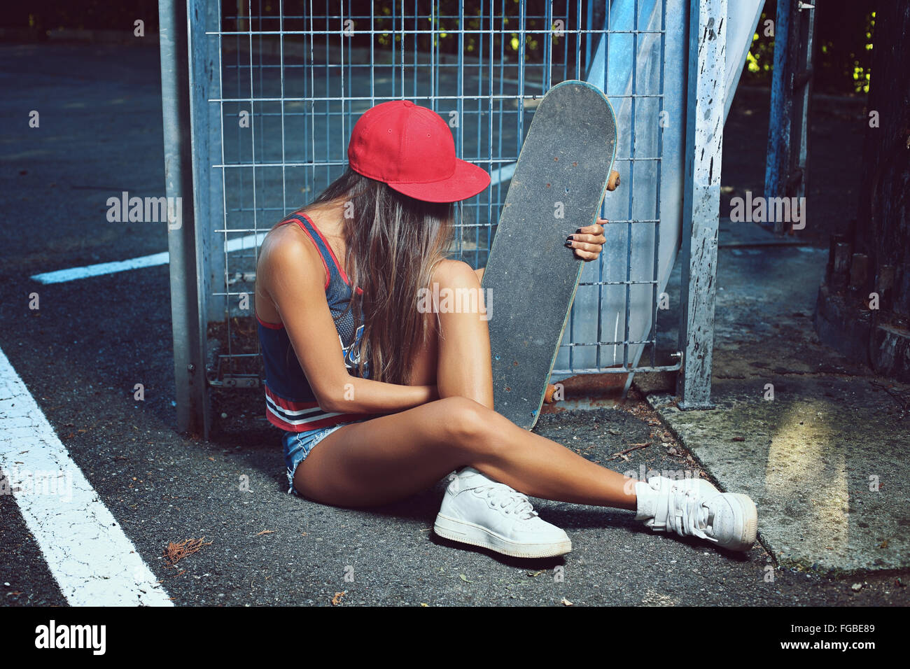 Chica Skater sentado en la calle . Filmación urbana Foto de stock