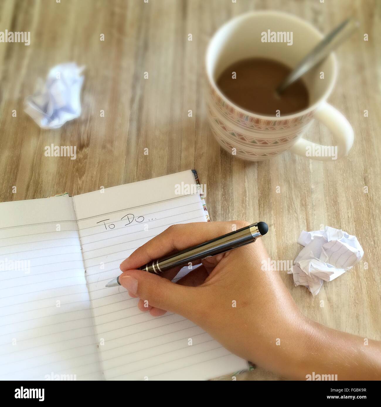 Planificación de mano recortada en el portátil con el café en la mesa Foto de stock