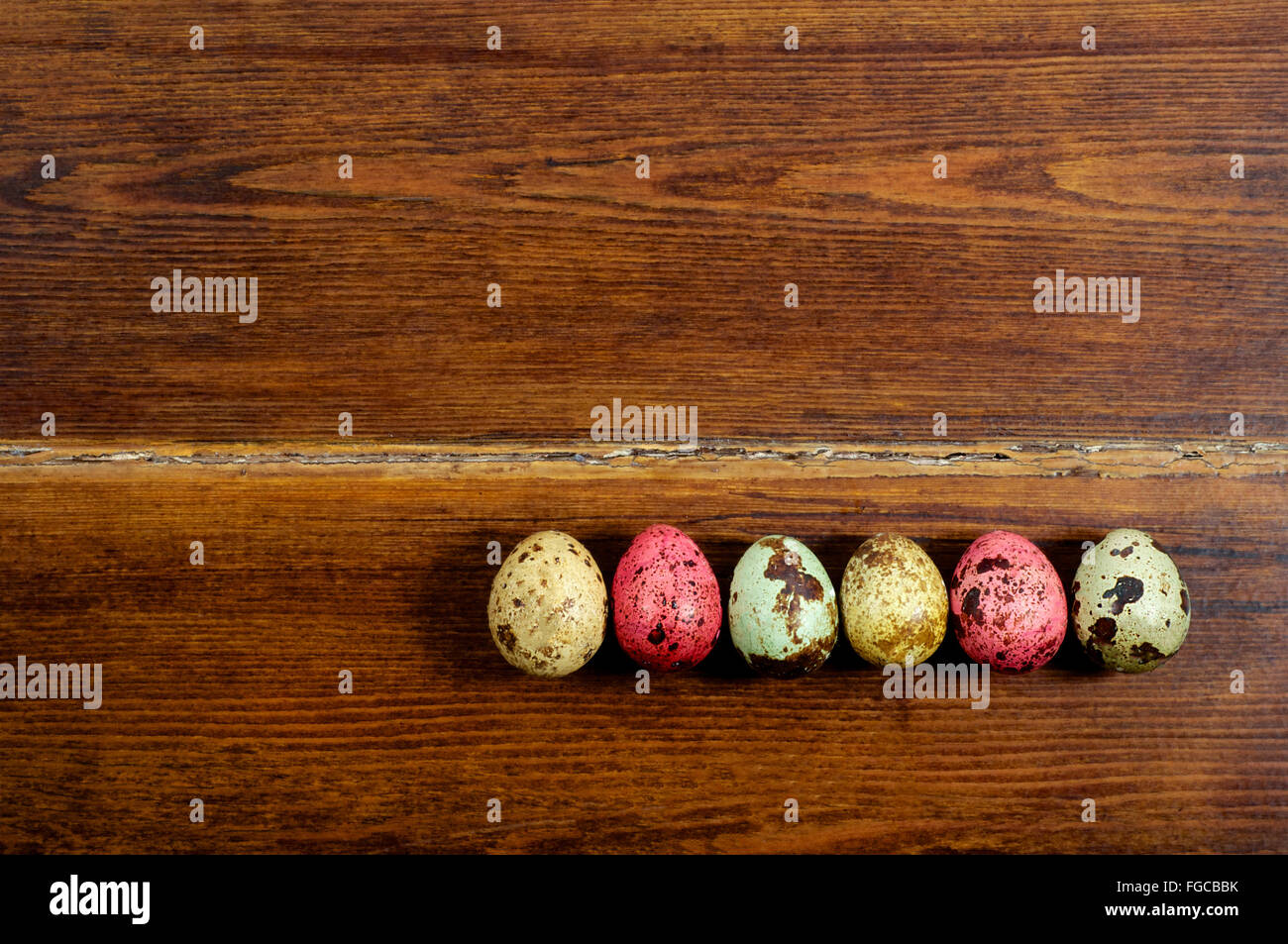 Varios coloridos huevos de codorniz sobre fondo de madera Foto de stock