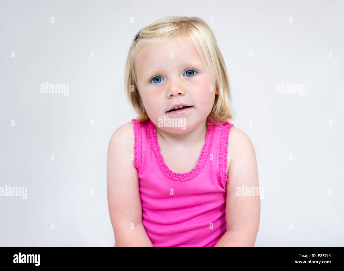 Retrato de una joven con corta el pelo rubio y ojos azules vistiendo un chaleco rosa sonriendo Foto de stock