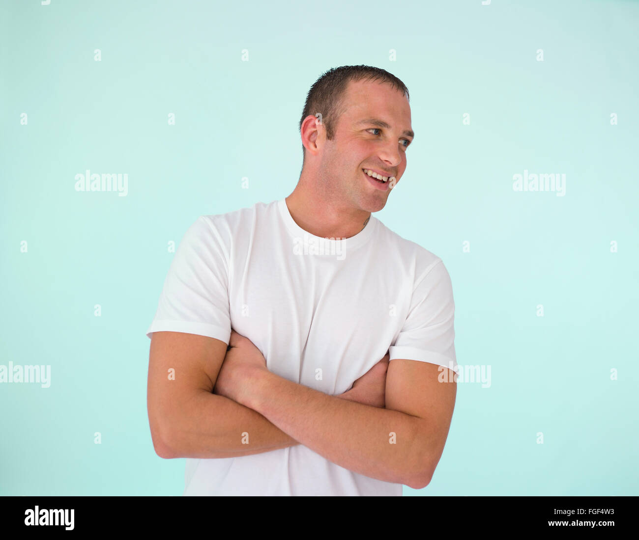 Hombre con los brazos cruzados, sonriendo Foto de stock