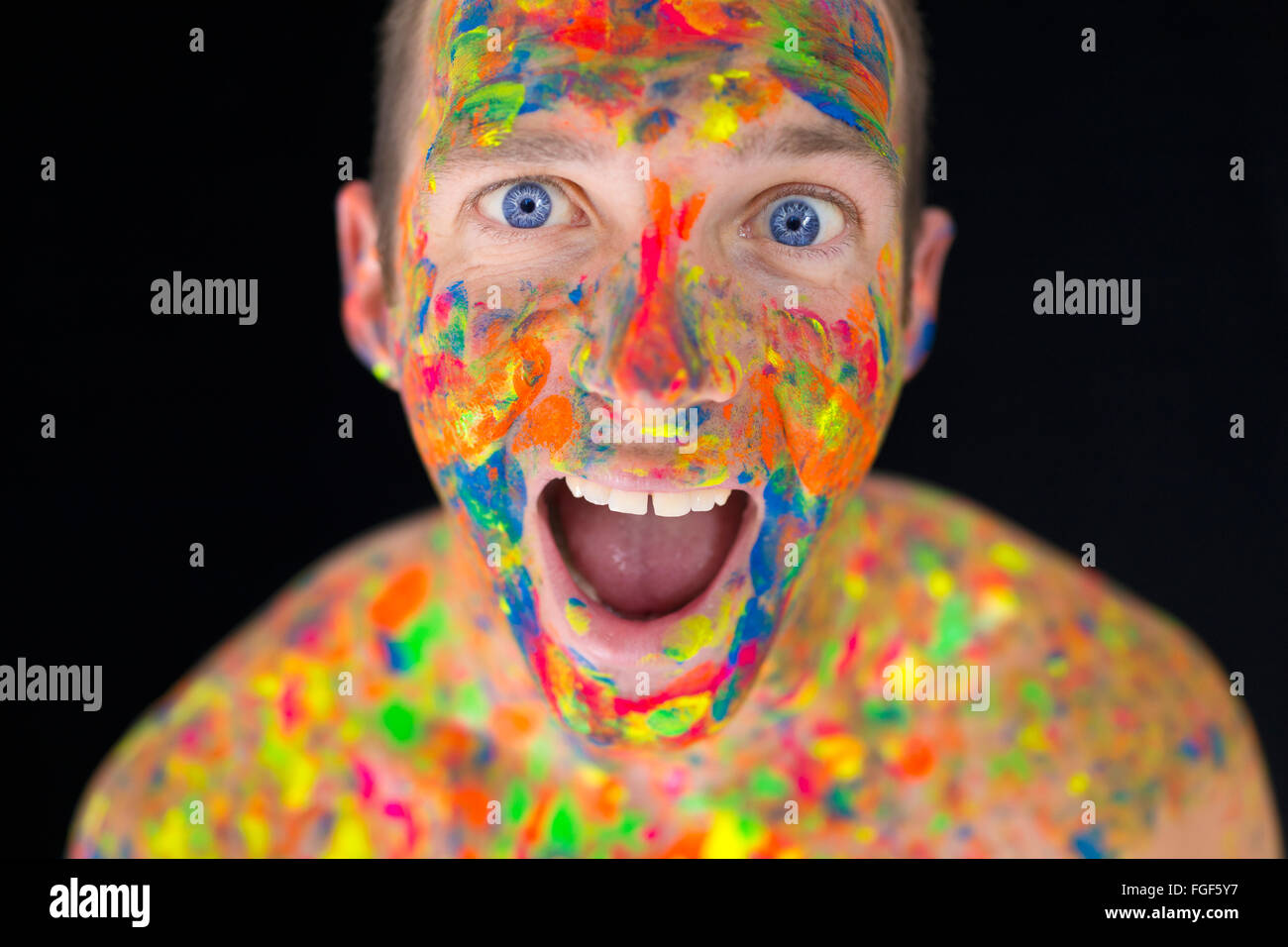 Primer plano de un hombre de la cara cubierta de pintura multicolor Foto de stock