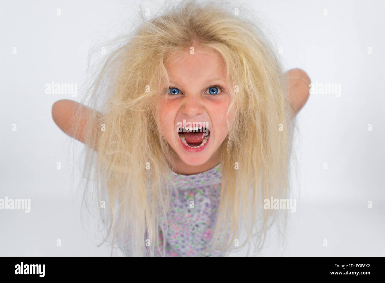 Niña con cabello rubio desordenado gritando Foto de stock