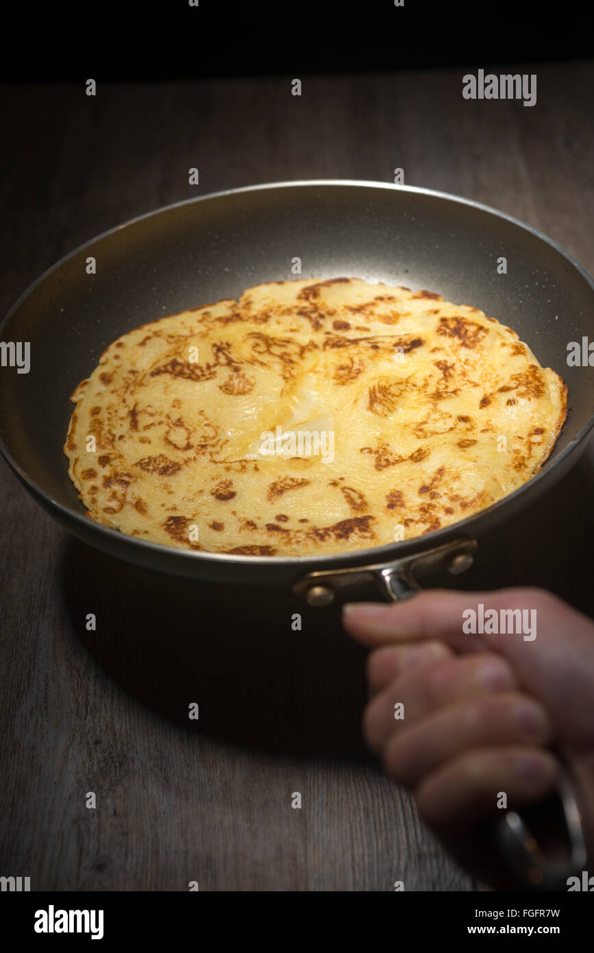 Foto horizontal del foco principal en el pancake está volteada en sartén  caliente en la parte superior de la estufa de gas gama Fotografía de stock  - Alamy
