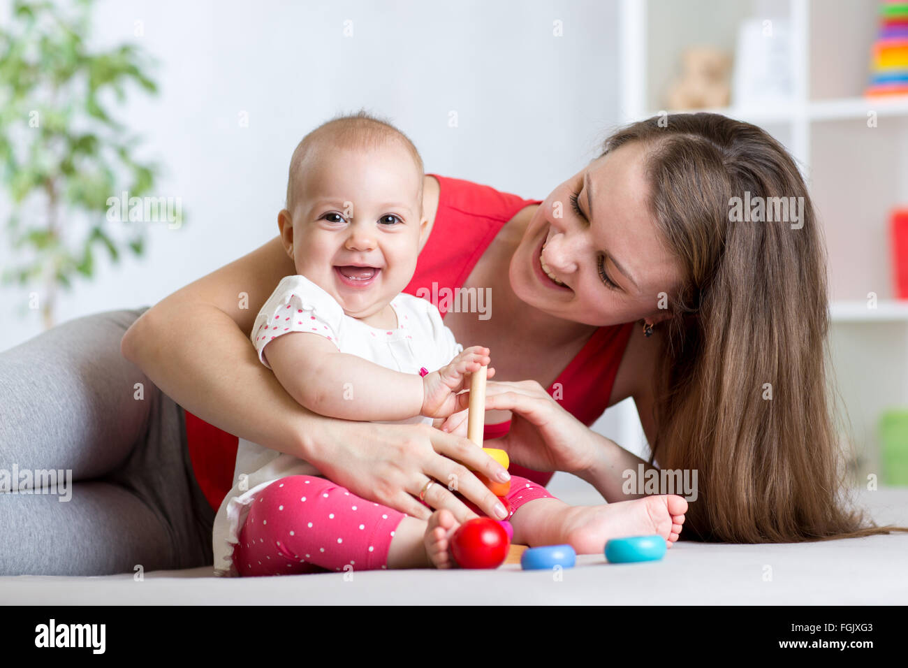 La madre y el bebé lindo jugar en casa interiores Foto de stock