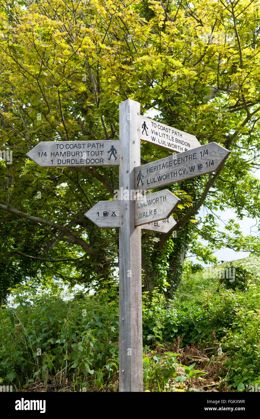 Cartel de madera para mostrar las direcciones de senderos alrededor de West Lulworth, Dorset, Inglaterra Foto de stock