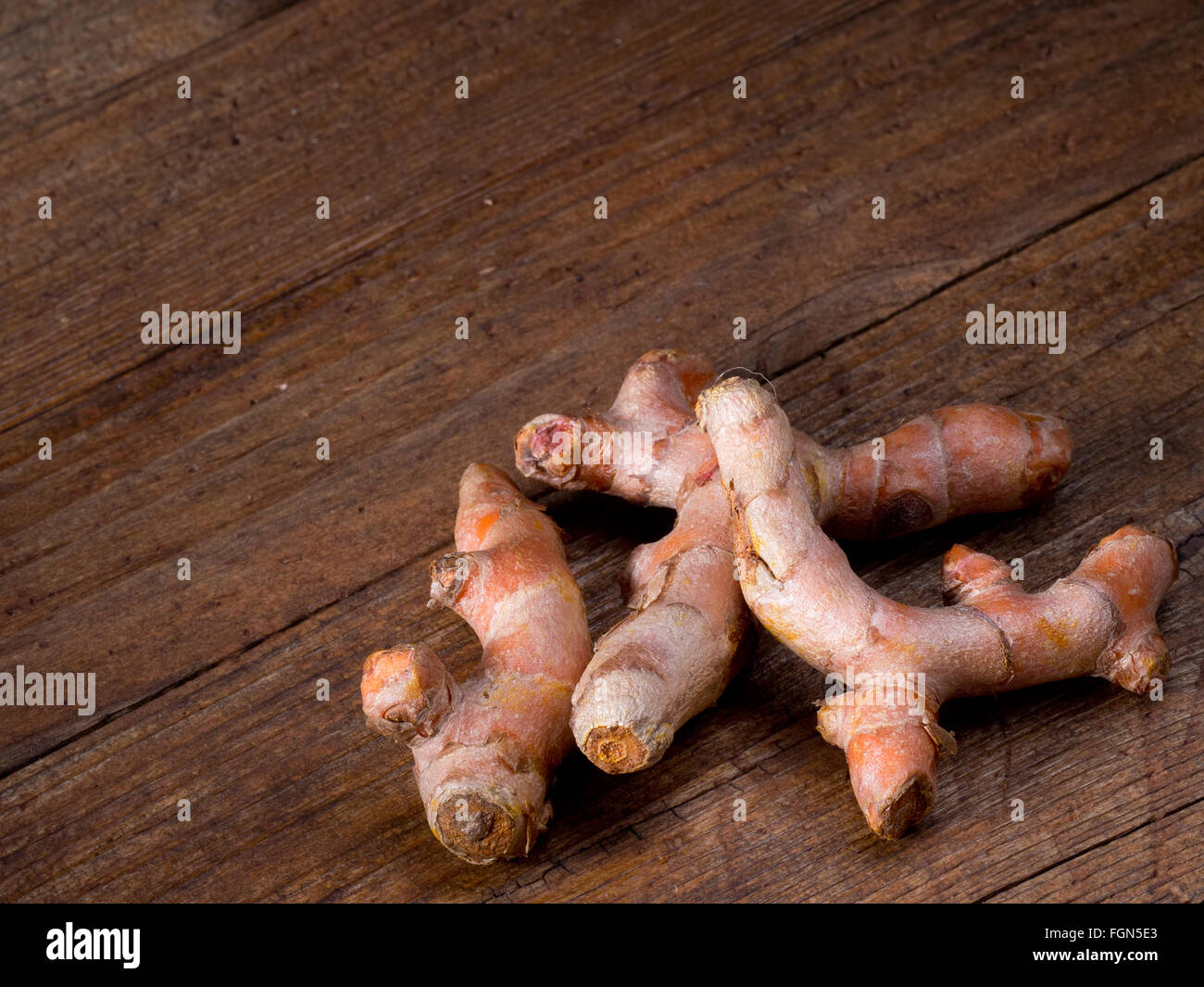 Raíz de cúrcuma, sobre fondo de madera rústica, junta. Medicinales. Foto de stock