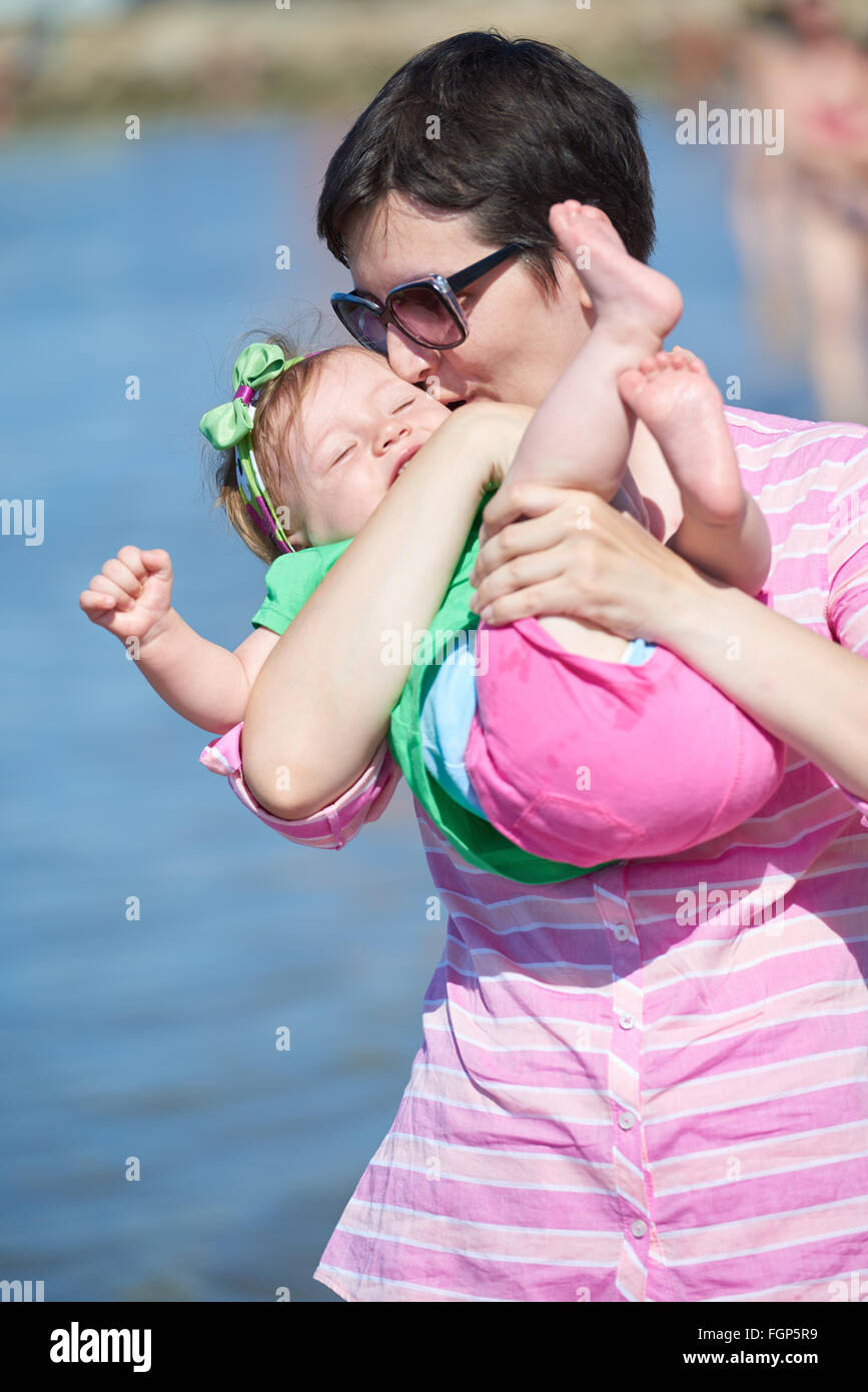 La mamá y el bebé en la playa diviértete Foto de stock