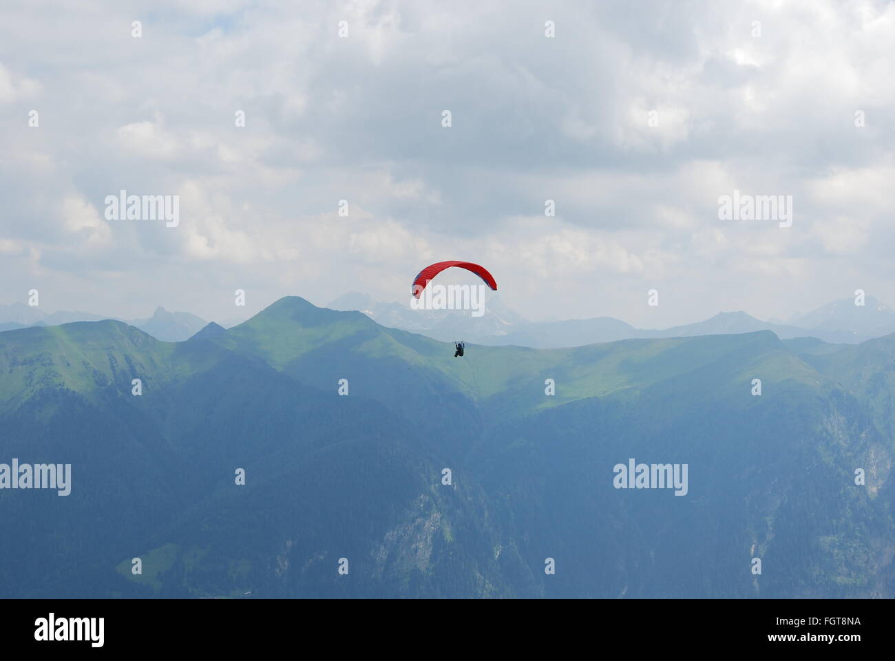 Paracaídas rojo en los Alpes en verano Foto de stock