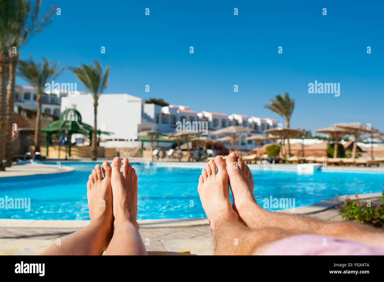 Las piernas masculinas y femeninas en el fondo de la piscina en el hotel Foto de stock