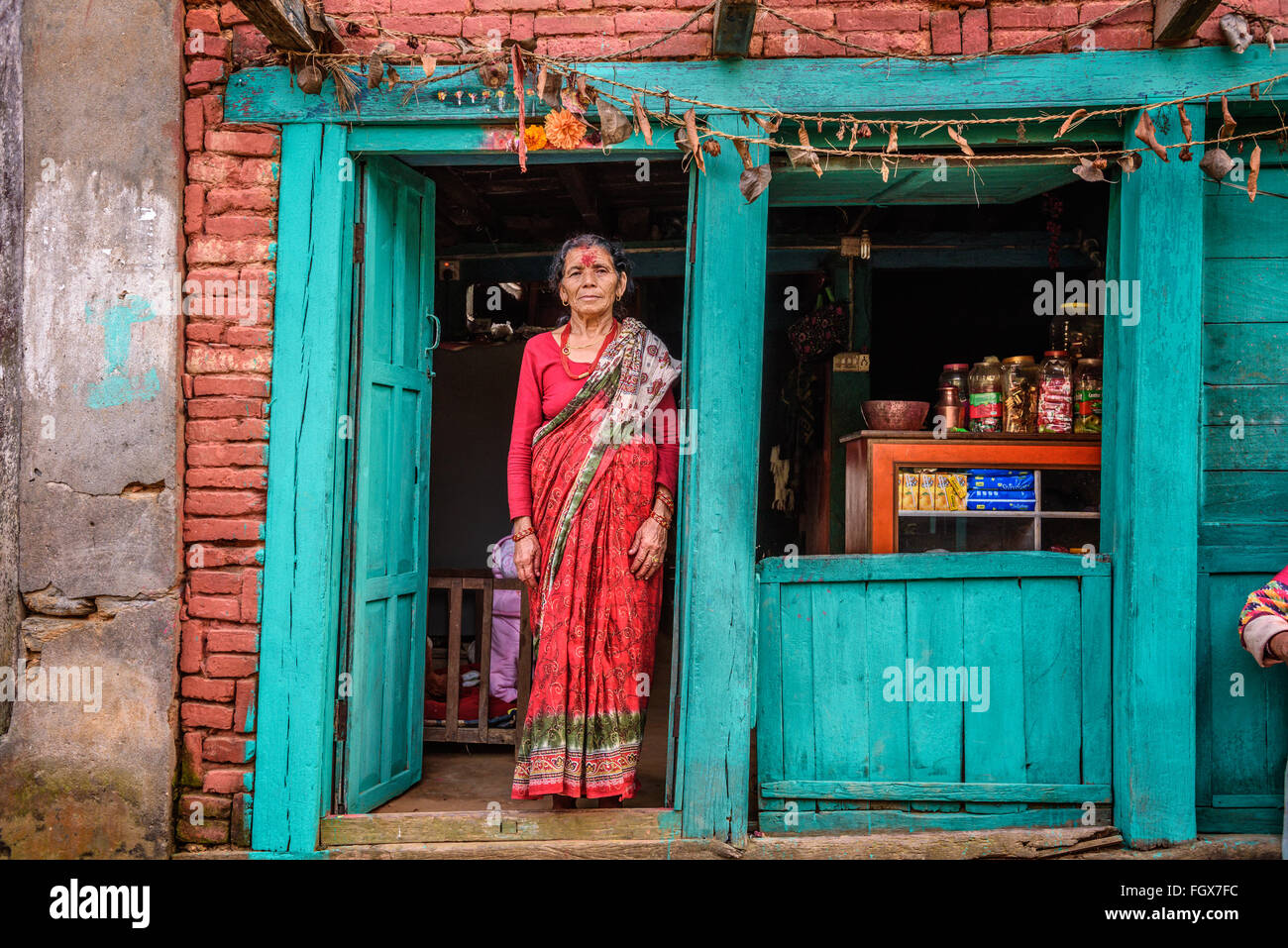 Vieja dama nepalés vende sus productos en su tienda. Foto de stock