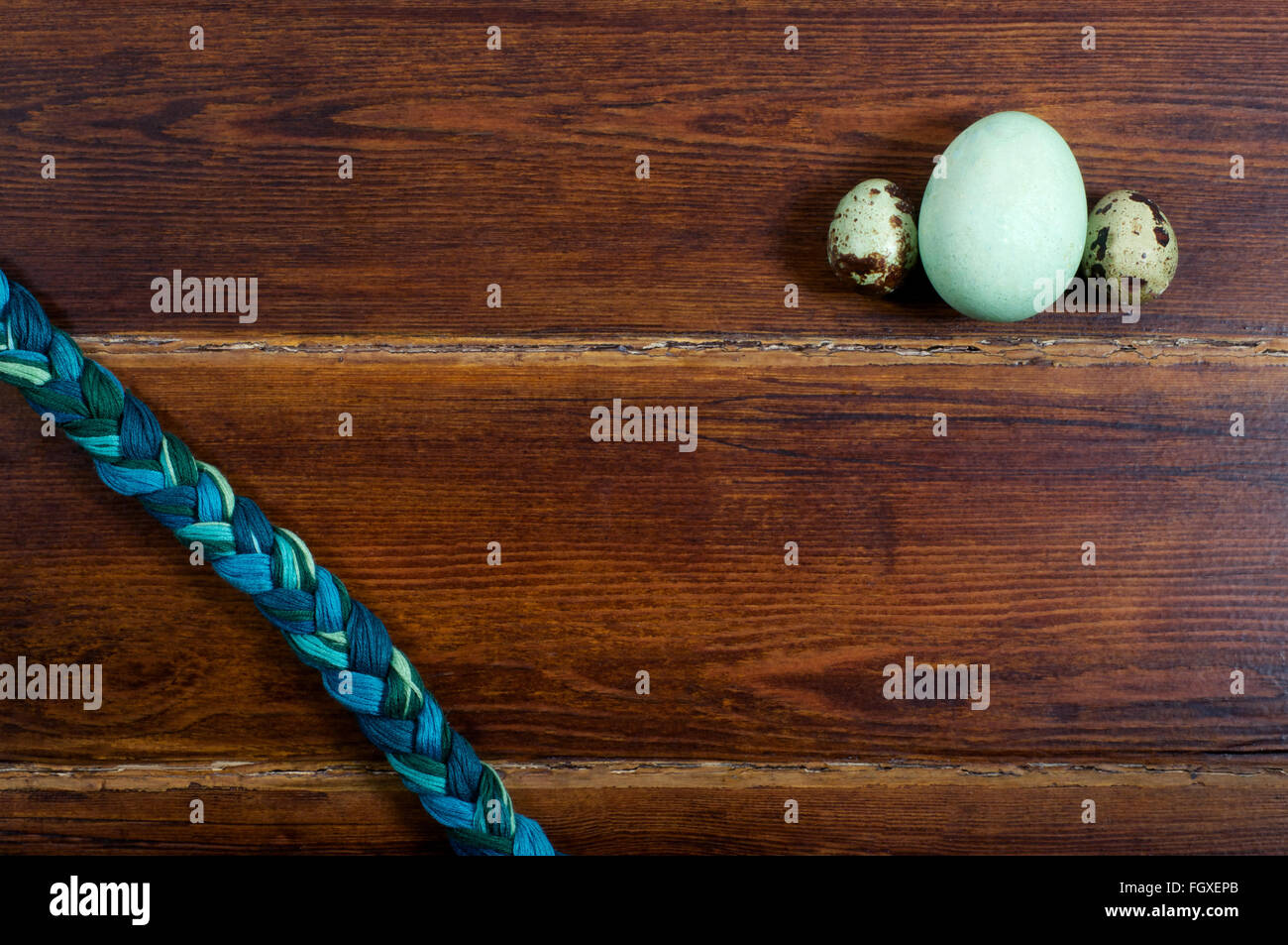 Huevos Verdes y huevos de codorniz con trenza moulinet sobre fondo de madera de la parte superior Foto de stock