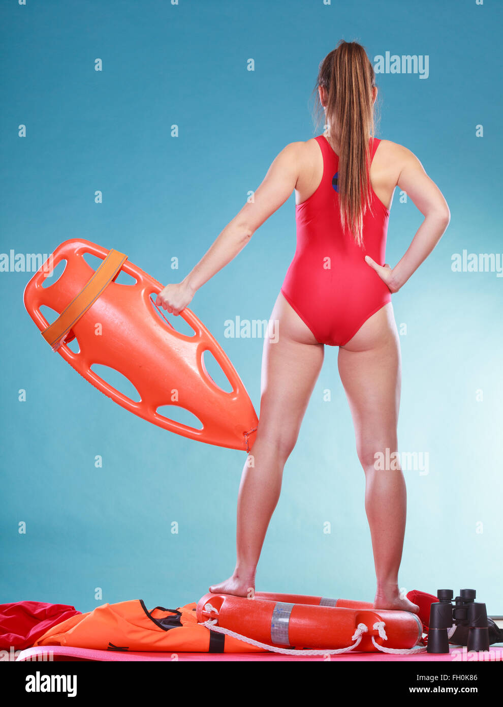 Socorrista con tubo de rescate boya. Mujer supervisa el agua de la piscina.  La prevención de accidentes y de rescate. Vista trasera Fotografía de stock  - Alamy