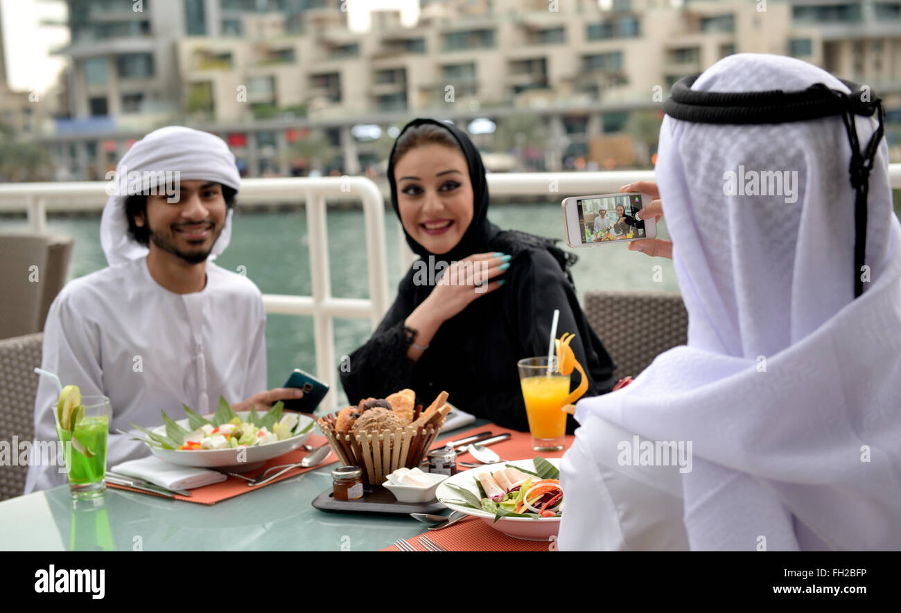 Los jóvenes de los emiratos árabes amigos cenando en un restaurante Foto de stock