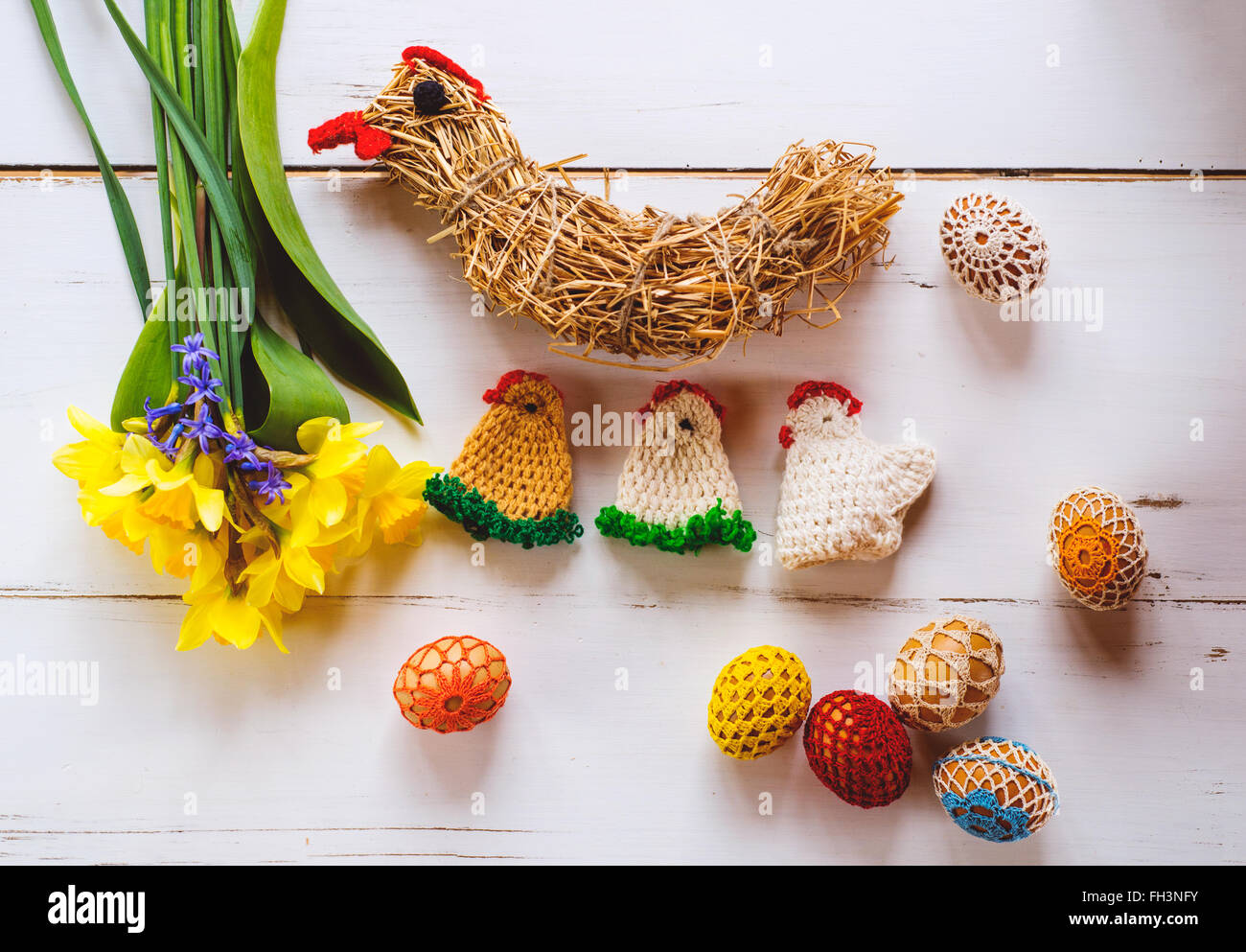 A ganchillo, pollos y huevos de Pascua narcisos, fondo de madera Foto de stock