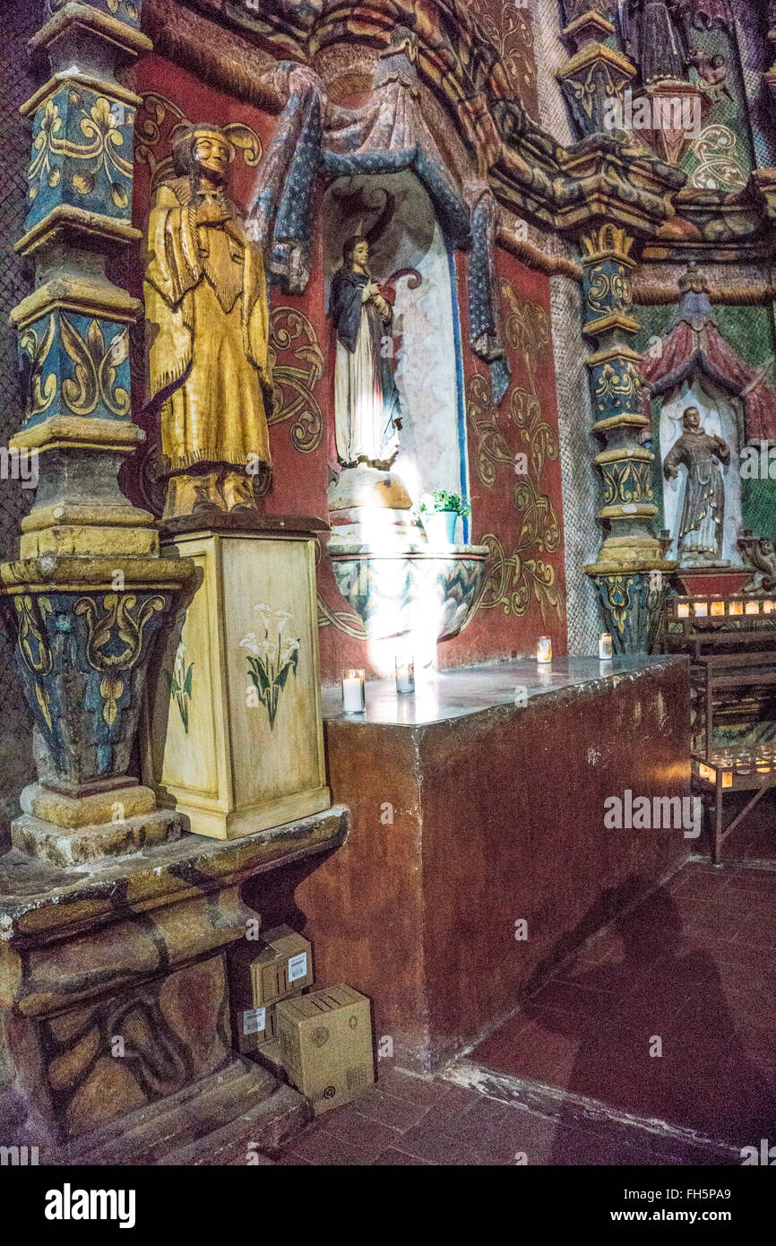 La primera estatua de madera dorada Americana Nativa Santa Kateri Tekakwitha entre ricamente coloreado objetos decorativos en la restaurada iglesia Foto de stock