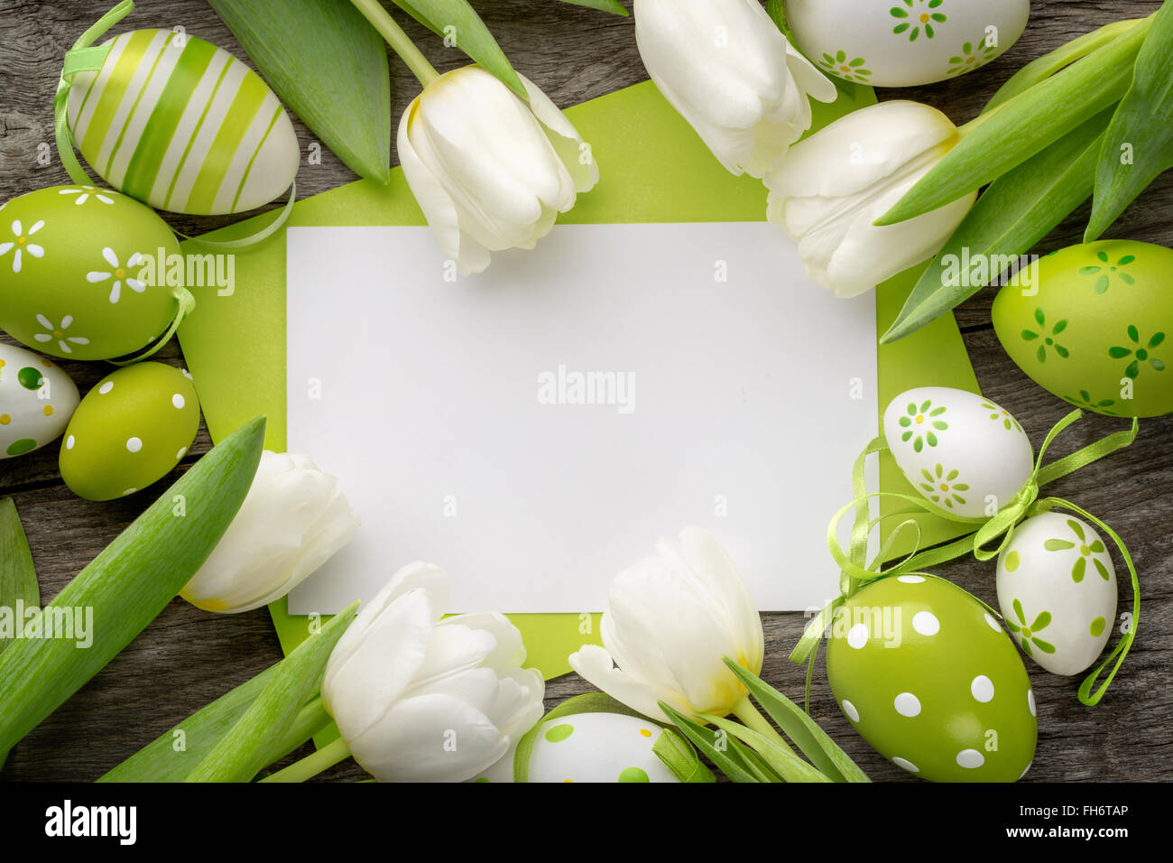 Huevo de pascua,tulipanes y tarjeta vacía para el texto. Foto de stock