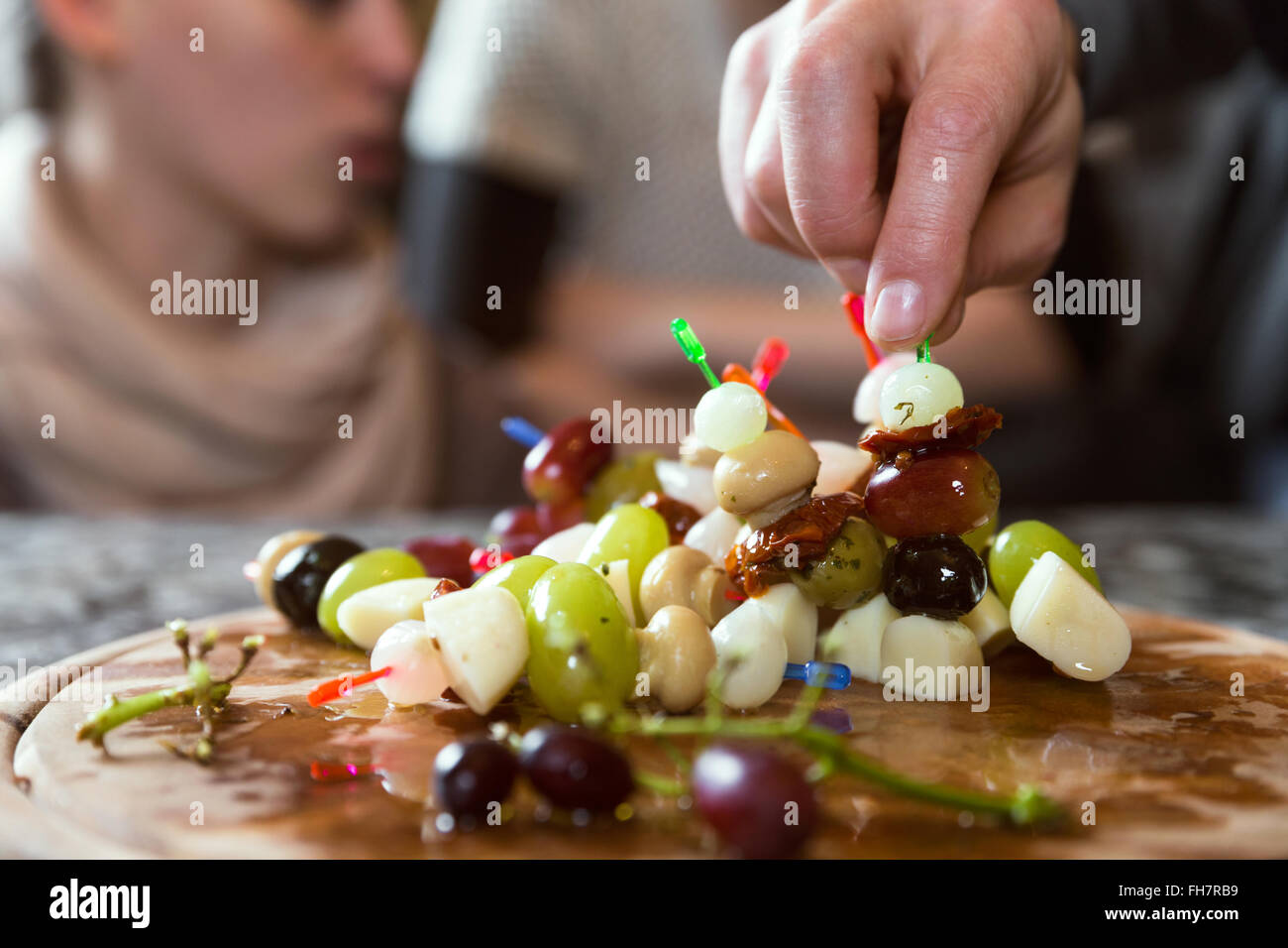 Placa con aperitivos del partido, un grupo de personas en el fondo Foto de stock