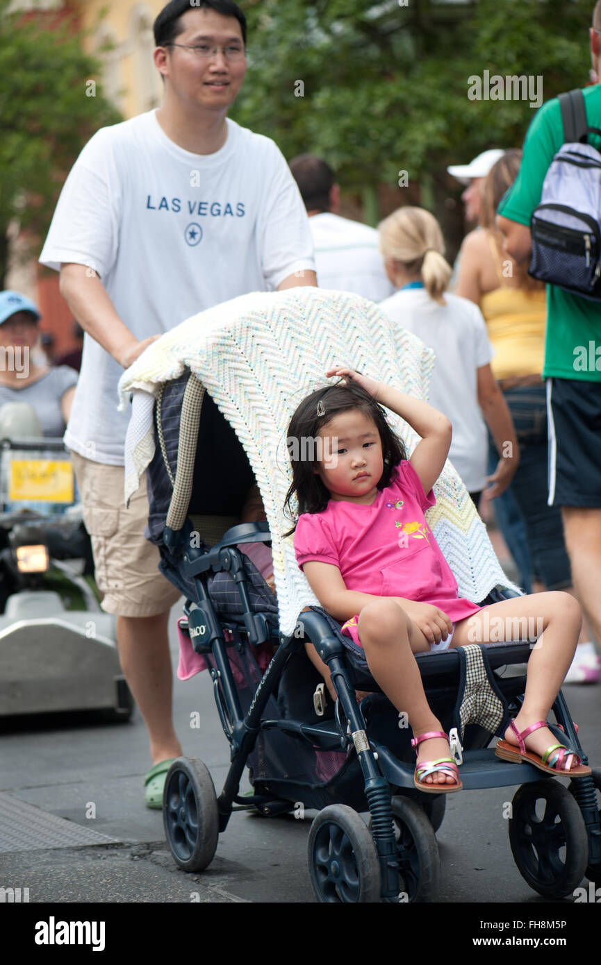 Papá asiático empuja su carro del bebé hija en el parque de atracciones de  Disney World en Florida EEUU a comienzos del verano Fotografía de stock -  Alamy
