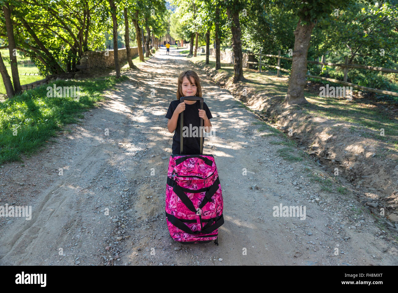 Pequeña niña cargando una maleta yendo de vacaciones al campo en españa  Fotografía de stock - Alamy