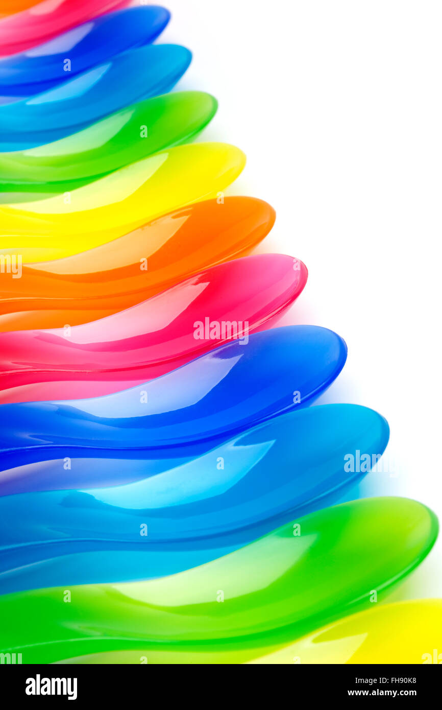 Rainbow cucharas de plástico de color sobre fondo blanco. Foto de stock