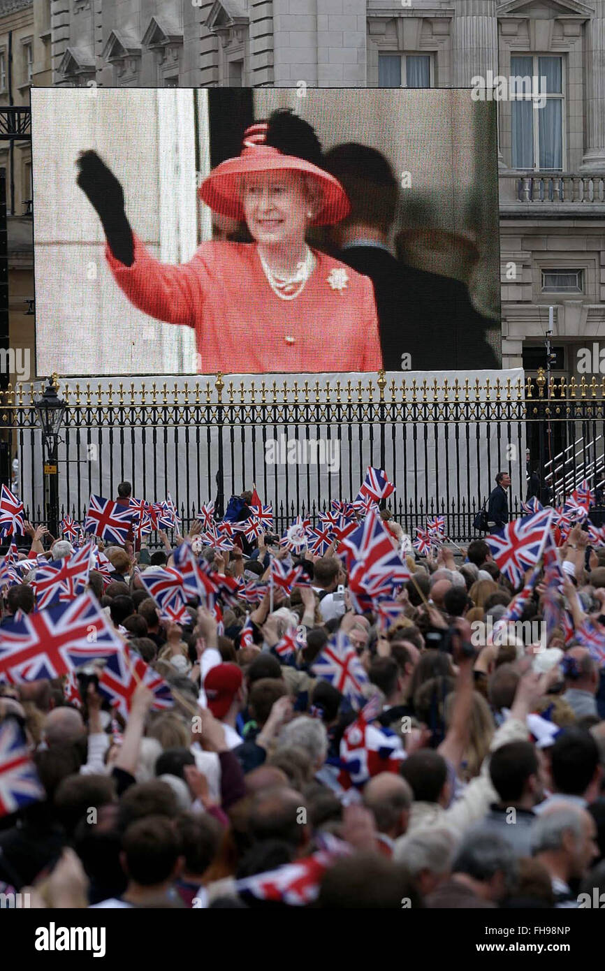 Las multitudes fuera del Palacio de Buckingham ver en una pantalla gigante de vídeo la aparición en el balcón de la Reina Isabel II, acompañada de otros miembros de la familia real británica, tras un concurso especial marcando su Jubileo de Oro que tuvo lugar fuera del palacio. Las celebraciones tuvieron lugar en el Reino Unido con la pieza central de un desfile y fuegos artificiales en el Palacio de Buckingham, la residencia londinense de la Reina. La reina Isabel subió al trono británico en 1952 tras la muerte de su padre, el Rey George VI. Foto de stock