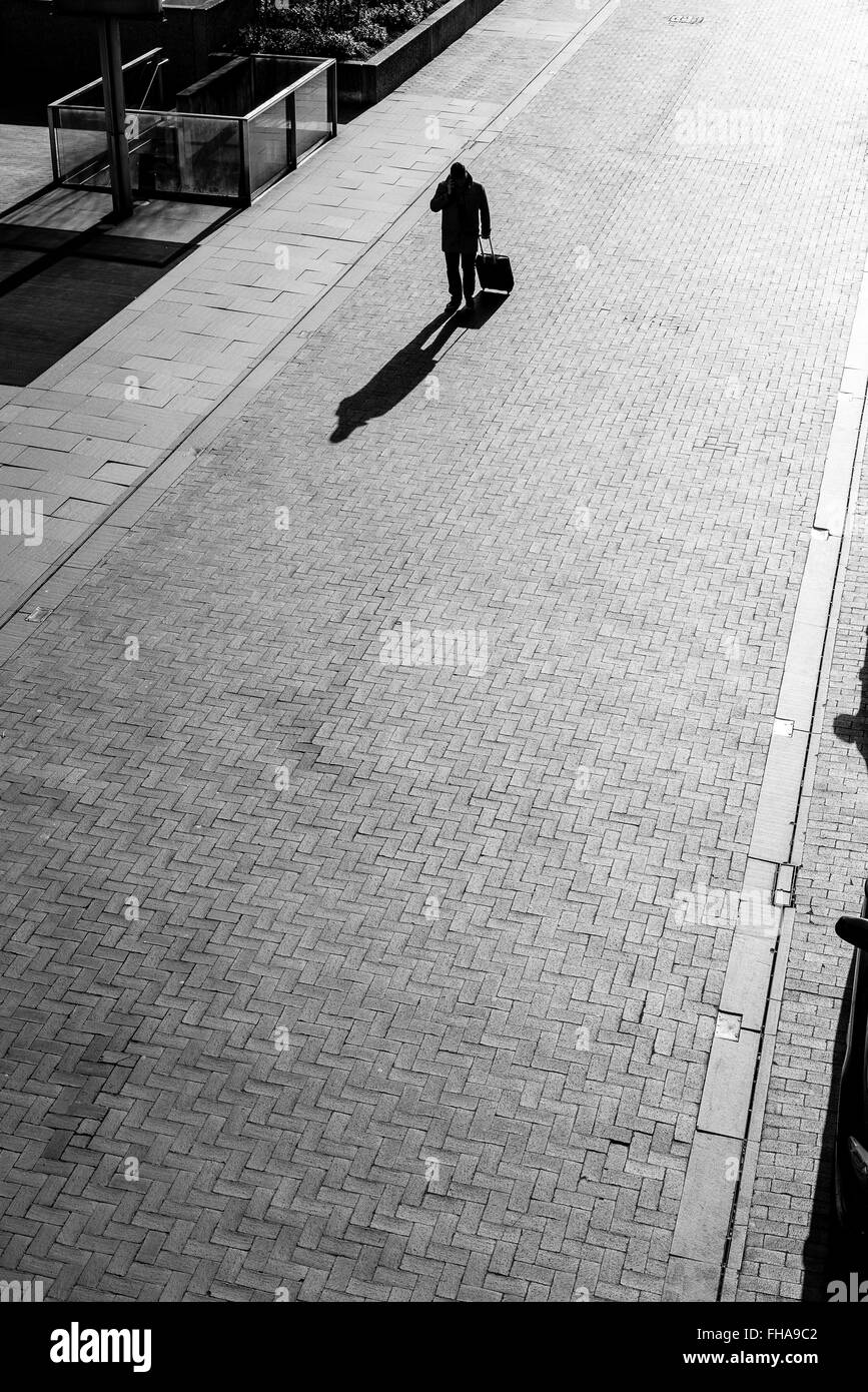 Un hombre solitario con una maleta camina hacia Southbank Foto de stock