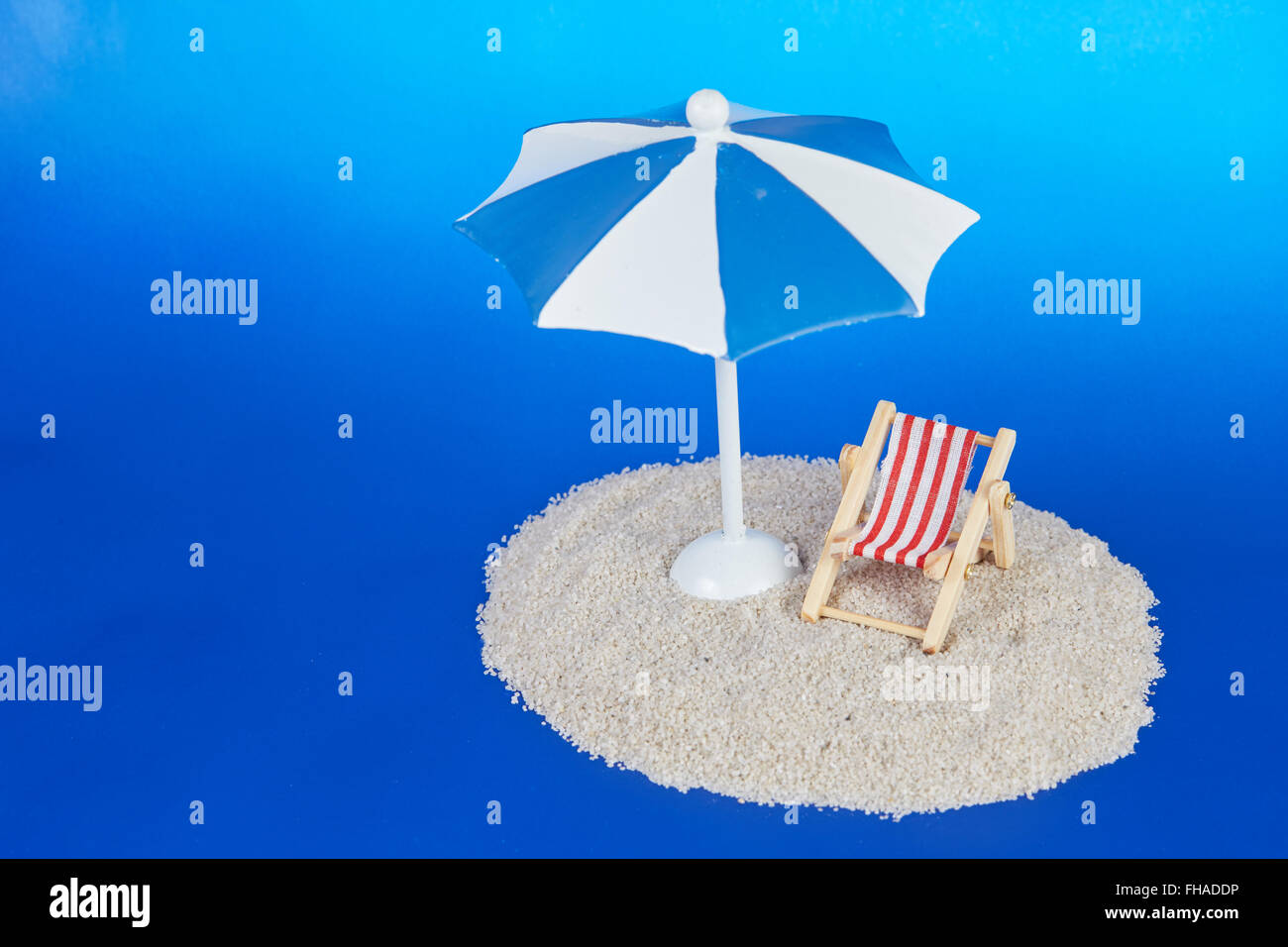 Isla de juguete con tumbona y sombrilla sobre fondo azul como concepto de  vacaciones con juguetes Fotografía de stock - Alamy
