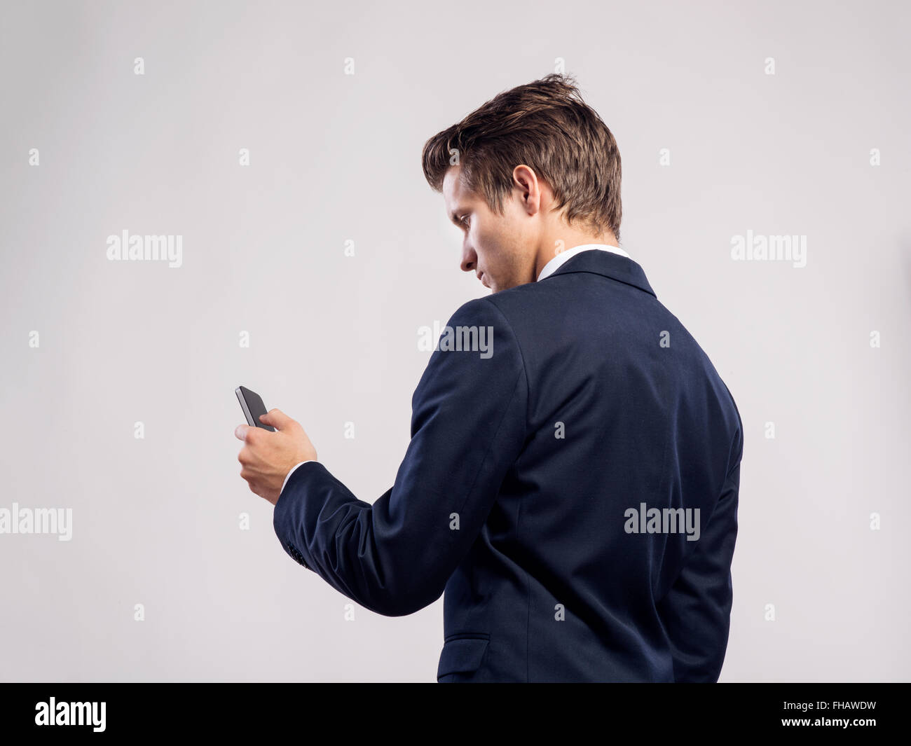 Hipster empresario smartphone con mensajes de texto. Foto de estudio, back v Foto de stock