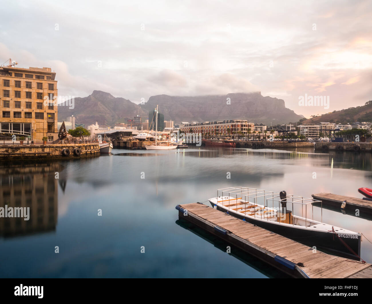 Waterfront en Ciudad del Cabo, Sudáfrica, dominada por la montaña de la Mesa al atardecer. Foto de stock