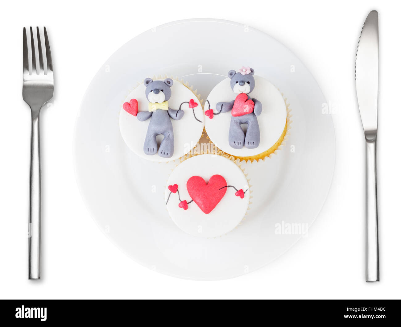 Cupcakes con oso de peluche y corazones en la placa aislado sobre fondo blanco. Plato de amor. Foto de stock