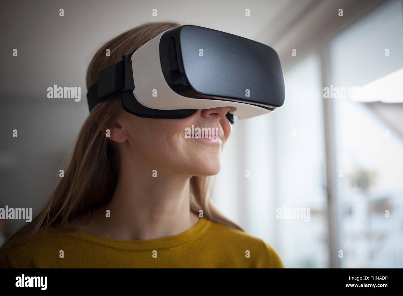 Mujer sonriente vistiendo gafas de realidad virtual Foto de stock