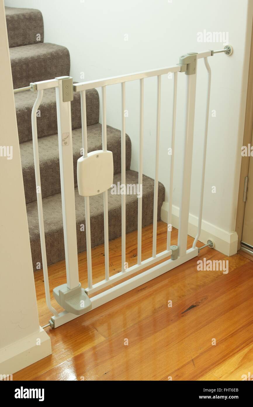 Puerta protectora blanca de seguridad para escaleras de bebé en el pasillo  escalera nueva y moderna valla de casa para niños en una hermosa casa