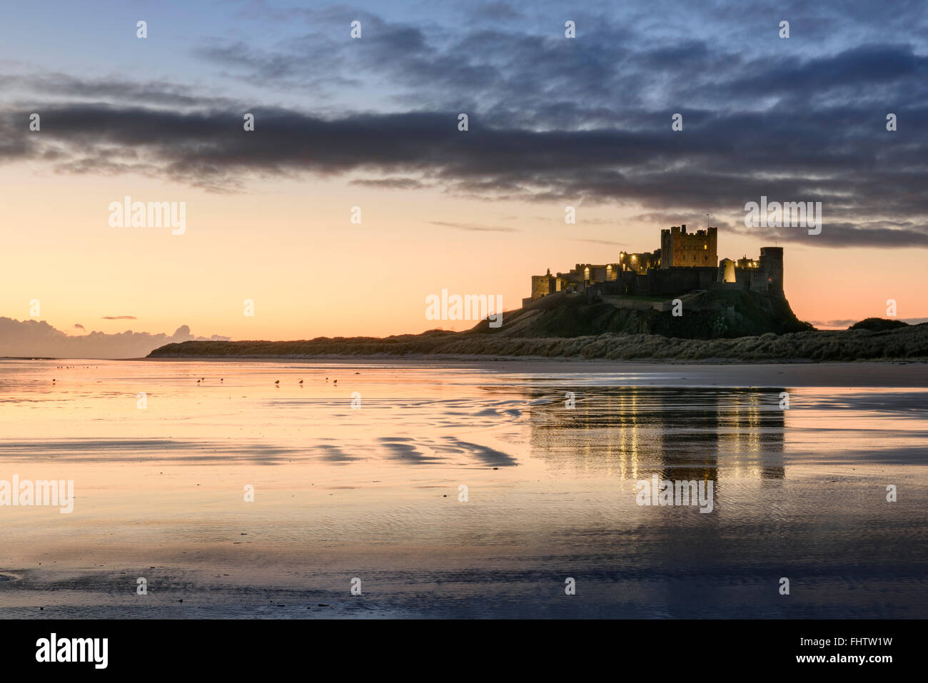 Bamburgh Castle y playa en Northumberland al amanecer Foto de stock