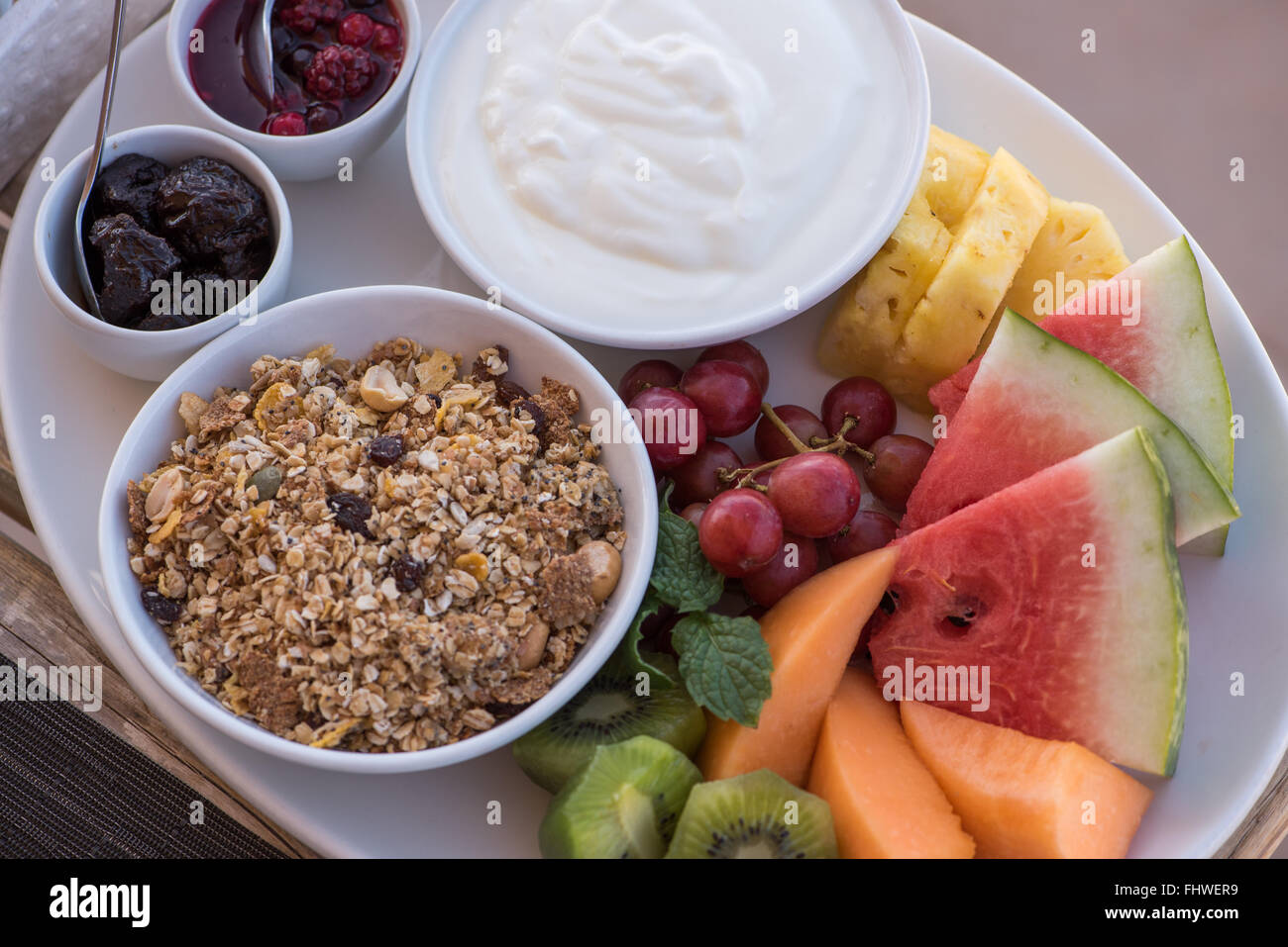 Vista aérea de un plato de frutas con muesli y yogur Foto de stock